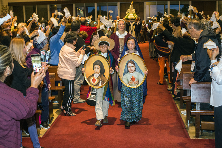 Luciano Garzon, 10, and Mariana Canedo, 10, dressed as the shepherd children St. Francisco and St. Jacinta, enter St. Michael Church followed by Sister Grace Heinrich of the Servants of the Pierced Hearts of Jesus and Mary.