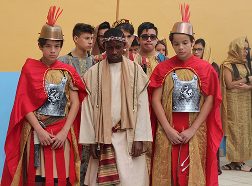 Mother of Our Redeemer eighth-graders, from left, Nicholas Lozano, Simeon Fleuridor and Jonathan Lozano re-enact Jesus' arrest during their Stations of the Cross presentation.