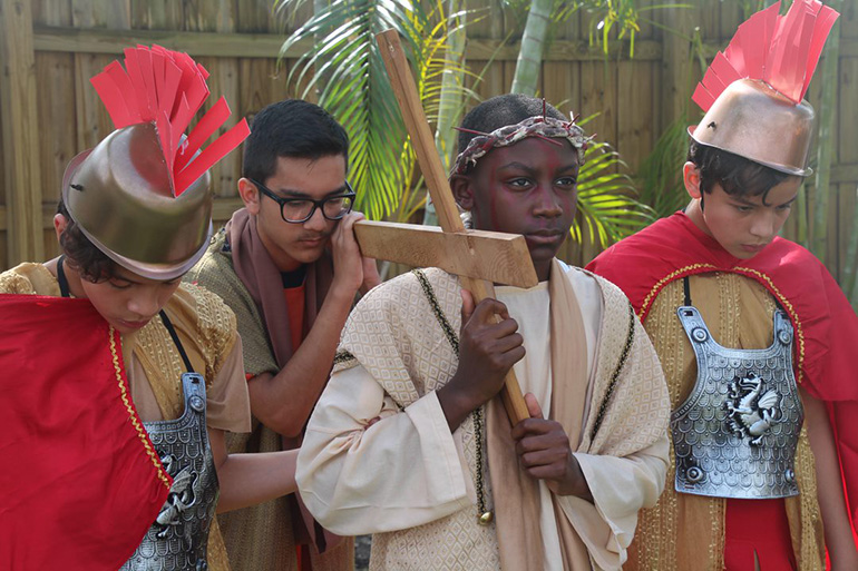 Mother of Our Redeemer eighth-graders re-enact Jesus carrying his cross. From left: Nicholas Lozano, Ricardo Machado, Simeon Fleuridor, and Jonathan Lozano.