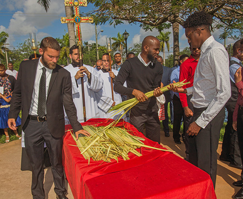 Mass-goers pick up the blessed palms at the start of Palm Sunday Mass, April 14, 2019.