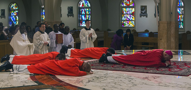 Archbishop Thomas Wenski begins the Good Friday Liturgy of the Passion of the Lord by lying prostrate in the sanctuary of St. Mary Cathedral.