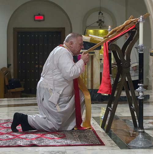 Archbishop Thomas Wenski venerates the Cross during the Good Friday service at St. Mary Cathedral.