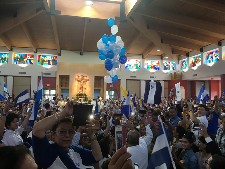 Hundreds of Nicaraguans living in South Florida came waving blue-and-white flags, banners, posters and even balloons to St. Agatha Church in Sweetwater April 28, to bid farewell to Bishop Silvio Báez, auxiliary bishop of Managua. He celebrated Mass there after a week-long stay in Miami with family before flying to Rome, where his presence was requested by Pope Francis.