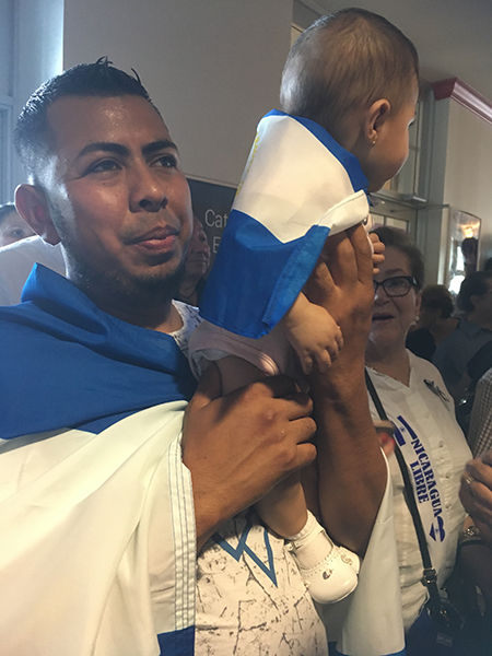 Jairo López and his daughter, Abigail, take part in the farewell Mass for Managua Auxiliary Bishop Silvio Báez. The Mass was celebrated at St. Agatha Church in Sweetwater April 28.