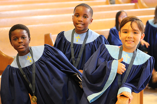 Dressed in the choir robes, Christian Celian, Dylhann Pierre, and Nicholas Cortes from St. Luke's Church choir in Palm Springs, a part of the Diocese of Palm Beach, pose for a photo before the start of Mass at the American Federation Pueri Cantores Festival at St. Bonaventure Church, Davie.