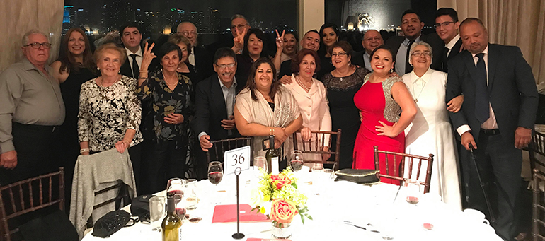 Ángelo Suazo (vestida de rojo), y su esposo (detrás) celebran con su comunidad Neocatecumenal.