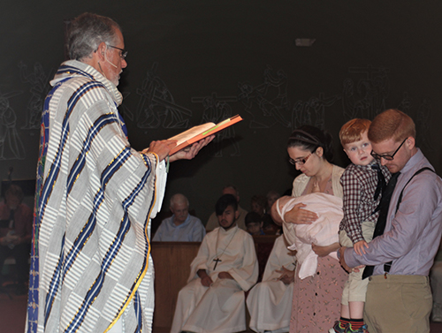 Father Robert Tywoniak, pastor of Blessed Sacrament Parish in Oakland Park, performs the ancient rites called the scrutinies during Mass March 24. Shown at the altar are Christopher and Kristin Booty. Both Christopher and his wife are Muslims who will be baptized into the Catholic Church during the Easter Vigil.