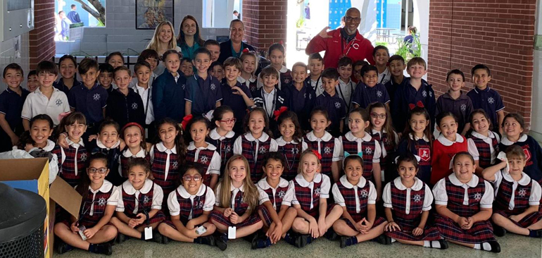 What a STREAM Day: First graders from St. Brendan School and their teachers stop for a group photo at Christopher Columbus High, where they spent the day experimenting in the lab with Columbus High AP Chemistry teacher Ludwig Baez and his students.