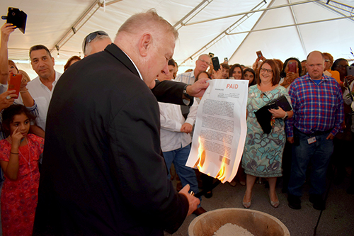 Archbishop Thomas Wenski sets fire to the paid-off mortgage of St. Edward Church.