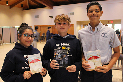 Historical fiction all around: St. Mark School students hold up their copies of "The Red Umbrella" and "A Thunderous Whisper," written by Christina Diaz Gonzalez. From left: Emily Cruz, Connor Cates and Pedro Jimenez.