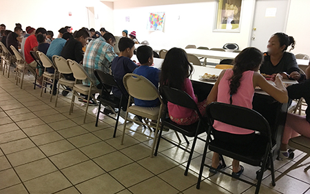 Un grupo de inmigrantes recién llegados al albergue Casa Oscar Romero, en El Paso, Texas, come una comida caliente, después de ser liberados por el Departamento de Homeland Security, ICE, en marzo pasado.