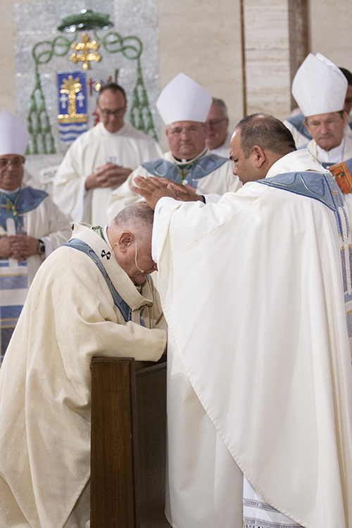 Father Martin Muñoz gives his first blessing to Archbishop Thomas Wenski at the conclusion of the ordination Mass.