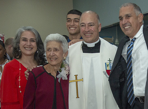 El P. Elkin Sierra toma un descanso de dar bendiciones para posar con su familia, desde la izquierda: su hermana Ana, su madre Stella, uno de sus sobrinos Vincent, de 18 años, y su hermano Luis, que también es bombero/paramédico.