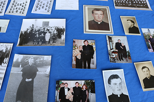 Photos of Father Thomas Foudy are displayed as part of a memorial to him May 19, the day he died. The photos were found at the parish days before his death when staff were looking for historical items to display for the parish's 60th anniversary celebration planned for the same day he died. The man who served the parish from 1989 to 2015 was loved by many and helped expand and grow the parish and school in many initiatives.