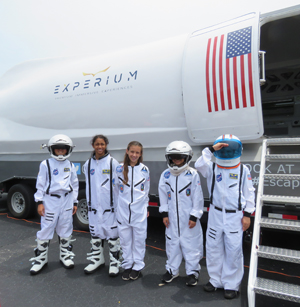 Niñas y niños astronautas: Los estudiantes de la escuela St. Ambrose están vestidos y listos para ser astronautas de la misión Experium Space Colony. El 7 y 8 de mayo, la sala de escape y simulador de STEM (Ciencia, Tecnología, Ingeniería y Matemáticas) les dio a los estudiantes la oportunidad de volar a Marte y resolver misiones en el Planeta Rojo.