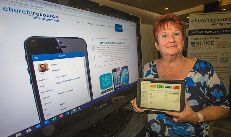 Stephanie Cate of Merchant Services displays merchant processing solutions, a new way for parishioners to contribute to their church via electronic giving. She was one of the exhibitors at the second Florida Statewide Stewardship Day.