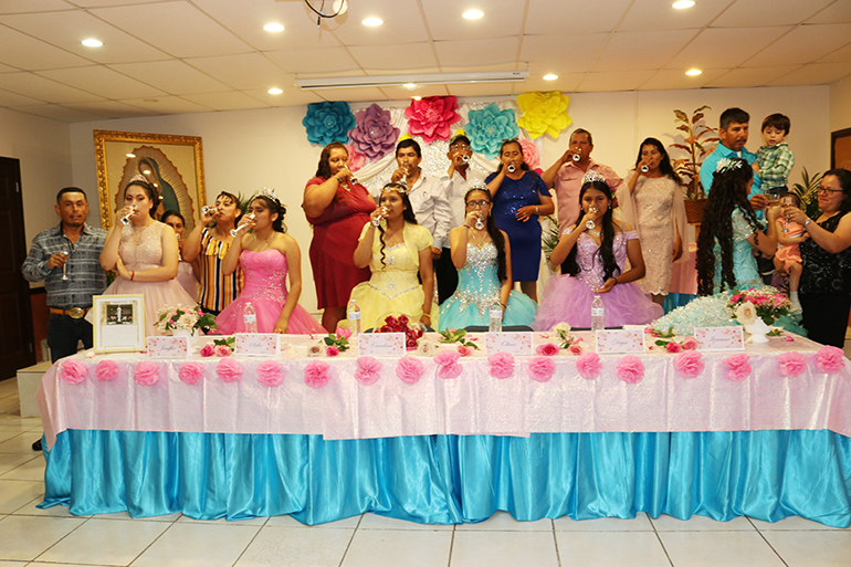 Las quinceañeras y sus familiares brindan al inicio de la fiesta en su honor. Seis familias de bajos recursos de la Misión Santa Ana, en Naranja, celebran los 15 años de sus hijas con una Misa y una fiesta en el salón parroquial. Toda la celebración se realizó gracias a los voluntarios que ayudaron con la decoración, la comida y bebidas, los vestidos y la música.