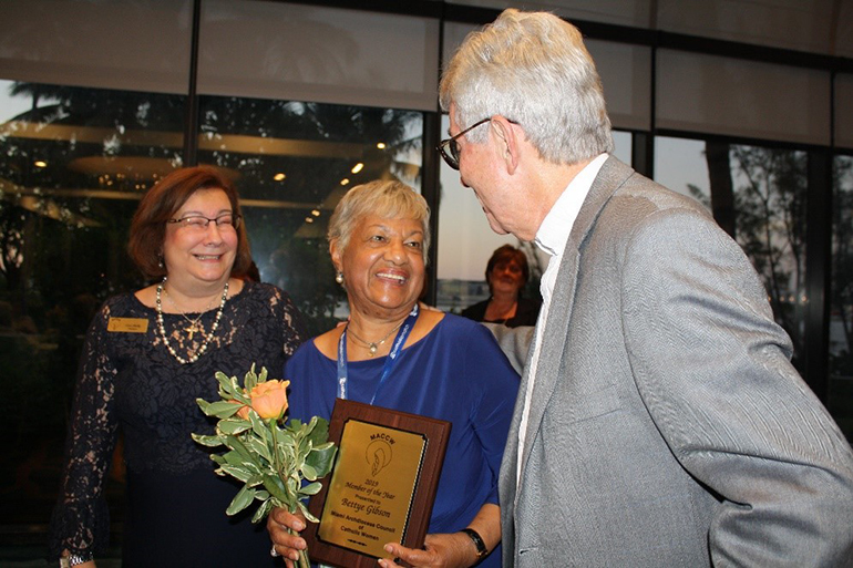 The Miami Archdiocesan Council of Catholic Women's Outstanding Member of the Year, Bettye Gibson of the Cathedral Council of Catholic Women, joyfully accepts her award from MACCW President Lisa Shelly and Father Michael J. Greer, the group's spiritual advisor, during the MACCW 61st annual convention at the Miami Airport Hilton May 17.