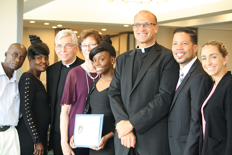 Scholarship Award recipient Christy Ramonvil, from St. Mary Cathedral School, poses with, from left, her stepfather, Pascal Phanor, her mother Ketelie St. Bert, Father Michael J. Greer, the Miami Archdiocesan Council of Catholic Women's spiritual advisor, Mary Weber, MACCW Scholarship Award coordinator, Father Christopher Marino, rector of St. Mary Cathedral, Edwardo Flor, cathedral school principal, and Katrina DeLaFe, assistant principal.