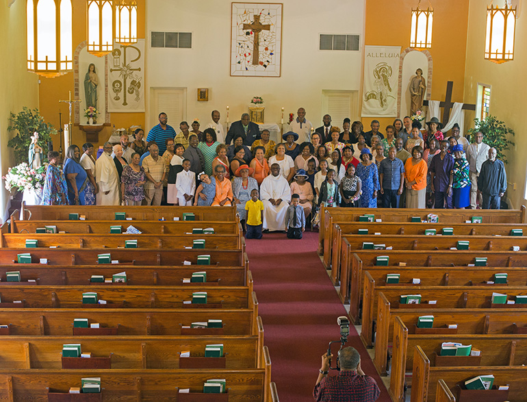 A photographer takes a photo of St. Philip Neri Church's parishioners following the 65th anniversary Mass.