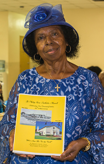 Lona B. Matthews holds the 47-page St. Philip Neri history booklet which she put together.