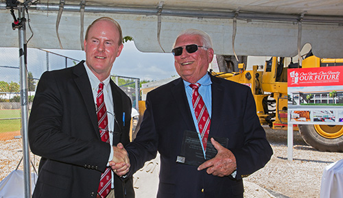 Thomas Mahon, left, incoming president at Cardinal Gibbons High, and Paul Ott, a 1966 graduate and outgoing principal, shake hands at the blessing and groundbreaking ceremony for the school's new STEAM center.