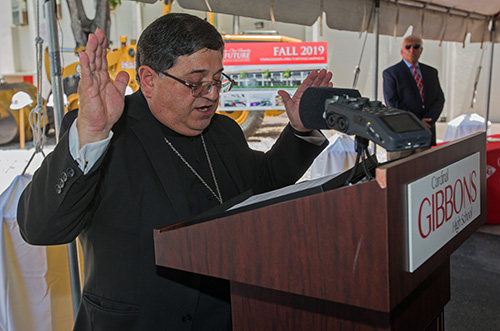 Bishop Enrique Delgado says a blessing at the groundbreaking ceremony for Cardinal Gibbons High School's new STEAM center.