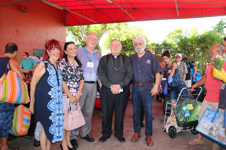 Durante el reparto de comida y la bendición del nuevo local del banco de comida de la Sociedad San Vicente de Paúl, en la parroquia Mother of Christ, aparecen junto al Arzobispo Thomas Wenski, desde la izquierda: Jossie Flores, coordinadora del banco de comida de la parroquia Mother of Christ; y los integrantes del concilio arquidiocesano de la Sociedad San Vicente de Paúl, María Pérez, actual presidenta; Jim Werle, tesorero, y Frank Voehl, anterior presidente.