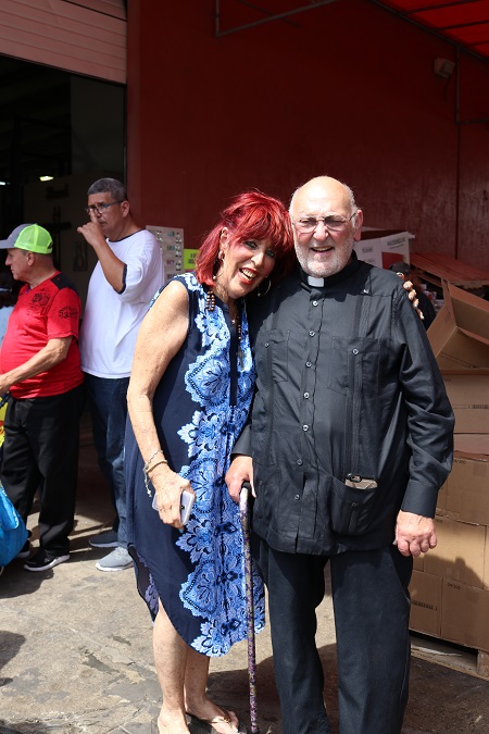 Jossie Flores, coordinadora del banco de comida de la Sociedad San Vicente de Paul, en la parroquia Mother of Christ posa con el P. Raúl Angulo, anterior párroco de Mother of Christ, durante la distribución de alimentos y bendición del lugar. Flores empezó el banco de comida en Mother of Christ hace 24 años con el apoyo del P. Angulo.