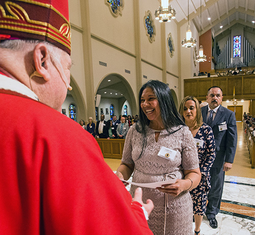 Luz Pena, graduada de la Escuela de Ministerio, recibe su Certificado de Estudios Católicos del Arzobispo Thomas Wenski, durante la Misa del 8 de junio de 2019, vigilia de la fiesta de Pentecostés, en la Catedral St. Mary.