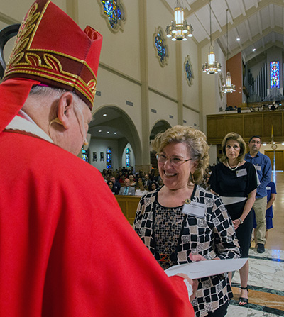 María Victoria Leander, de la parroquia St. Rose of Lima, en Miami Shores, recibe su certificado de Ministerio de Vida Espiritual del Arzobispo Thomas Wenski, durante la Misa del 8 de junio de 2019.