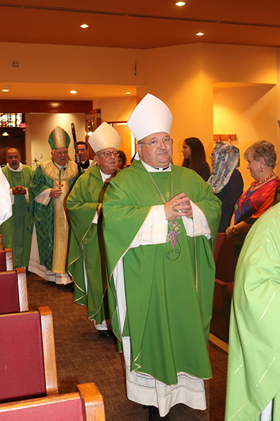 Auxiliary Bishop Peter Baldacchino processes into St. Martha Church for the farewell Mass celebrated at the Pastoral Center June 14. Entering with him are Archbishop Emeritus John Favalora and Archbishop Thomas Wenski.