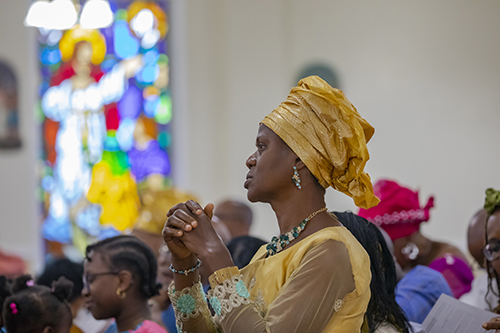 A member of the Archdiocese of Miami's Nigerian Apostolate prays during the Mass celebrating 25 years of the apostolate's establishment, June 16, 2019 at St. Monica Church, Miami Gardens.