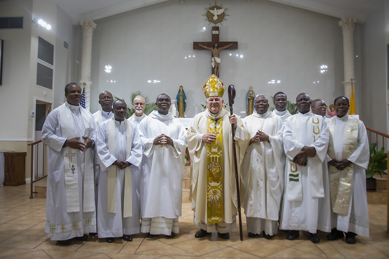 Archbishop Thomas Wenski poses with the five Nigerian pastors of the Archdiocese of Miami and visiting priests who concelebrated the Mass for the Nigerian Apostolate's 25th anniversary, June 16, 2019 at St. Monica Church, Miami Gardens. The Mass was celebrated in both Igbo and English.