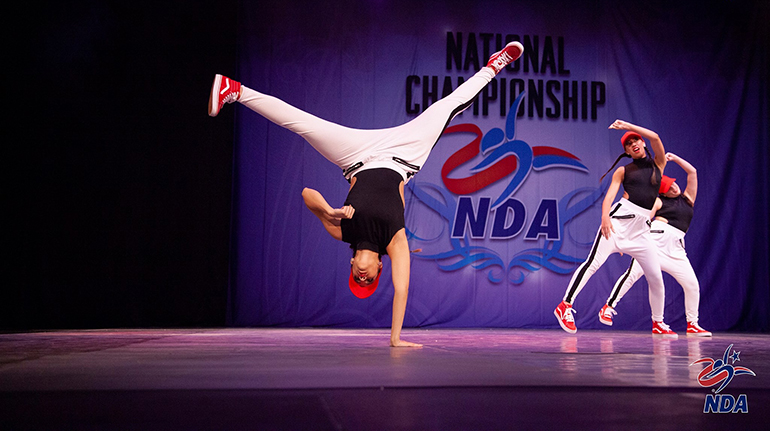 Archbishop McCarthy High School's Madison Rojas does a trick as Marcela Atehortua and Amber Romero move in the background during the Jazz competition at the National Dance Alliance's National Championship in Orlando in February.