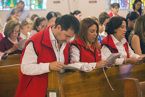 Fabrizio and Monica Acquaviva, of Mission for the Love of God Worldwide, pray the rosary before the Mass where Archbishop Thomas Wenski consecrated the Village of Key Biscayne to the Sacred Hearts of Jesus and Mary.