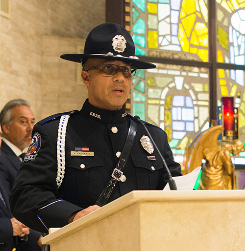 Key Biscayne Honor Guard member, Officer Frank Carvajal, reads one of the Prayers of the Faithful during the Mass of consecration for the Village of Key Biscayne.