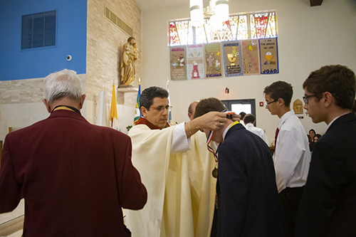 Father Juan Carlos Paguaga presents a student-athlete with a medal during the All Catholic Conference All Star Mass held at St. Agnes Church in Key Biscayne on May 5.