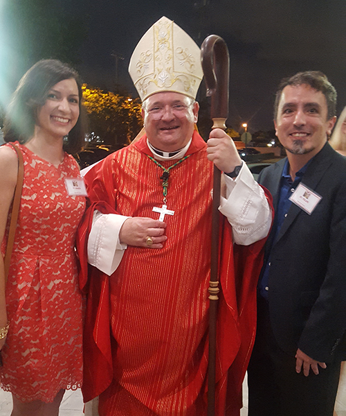 Cristina Cabrera Jarro y su hermano, Felipe Cabrera Jarro, se retratan con el Obispo Peter Baldacchino después de haber recibido el sacramento de la confirmación en la iglesia de la Inmaculada Concepción en Hialeah.