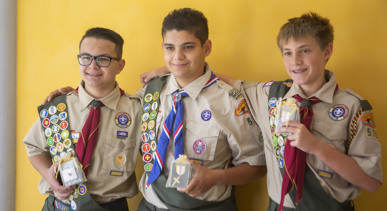 From left, Sebastian Gomez, Anthony Arteta and Zachary Seymour show the emblems they received at the Archdiocese of Miami's Catholic Scouting Presentation Mass.