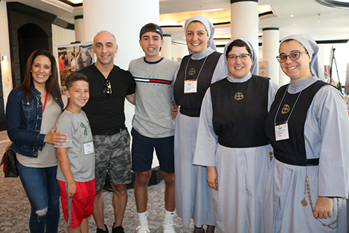 George Frem of Boston, his wife Rania and their two sons gather with members of the Servants of Christ the Light from Dartmouth, Massachusetts during the Maronite convention in Miami. The religious community, marking its 10th anniversary, is the first Maronite religious congregation established in the United States. Shown left to right are Sisters Therese Maria Touma, Sister Marla Marie Lucas, foundress of the community, and Sister Natalie Sayde.