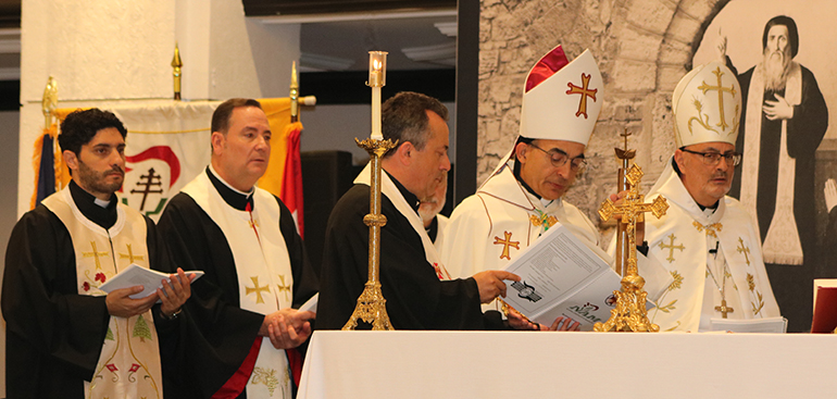 Los dos obispos de la Iglesia Católica Maronita de los Estados Unidos celebran la Misa o la Liturgia Divina durante la Convención Nacional Maronita, celebrada en Miami del 26 al 30 de junio. El Obispo Abdallah Elias Zaidan, eparca de Nuestra Señora del Líbano de Los Ángeles, a la izquierda, y el Obispo Gregory John Mansour, eparca de St. Maron de Brooklyn, se encuentran en el altar con algunos de los más de 100 clérigos que participaron. En el extremo izquierdo esta el P. Elie Saade, de la parroquia Our Lady of Lebanon en Miami, y junto a él, se encuentra el caballero Michael Thomas, de la parroquia Heart of Jesus, en Fort Lauderdale. Los miembros de la parroquia de Nuestra Señora de Líbano fueron los anfitriones de la convención nacional patrocinada por el Apostolado Nacional de Maronitas.