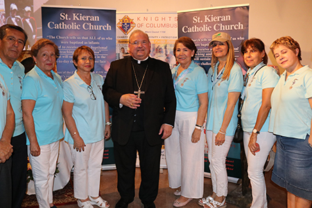 EL Obispo Peter Baldacchino posa con los integrantes del movimiento Legión de María, en la parroquia St. Kieran, durante la despedida que los feligreses de esa parroquia le realizaron.