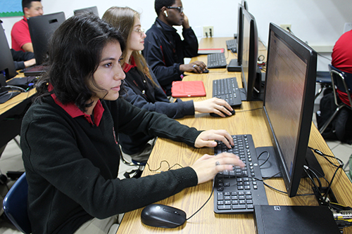 Programando: La estudiante de Mons. Edward Pace High, Vanessa Pérez Robles, escribe un programa de computadora durante una clase. Se acaba de graduar de la escuela con una beca de Amazon para Futuros Ingenieros, y una beca completa a la prestigiosa universidad de Dartmouth. Trabajando junto a Vanessa están Sabina Rivero y Chrystopher Creed.