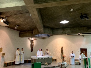 Msgr. Kenneth Schwanger, pastor of Our Lady of Lourdes Parish in Miami, reads the Prayer of the Faithful as Archbishop Thomas Wenski and concelebrating priests listen during a "healing Mass" celebrated July 4, 2019, at a chapel dedicated to St. Joseph in Lourdes, France.