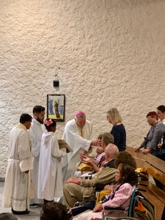 Archbishop Thomas Wenski anoints the sick with holy oil while celebrating a "healing Mass" July 4, 2019, at a chapel dedicated to St. Joseph in Lourdes, France.