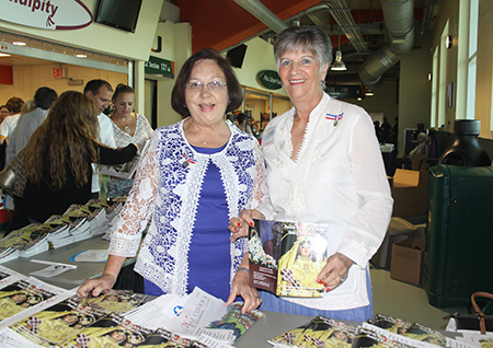 Neida Larosa (izquierda) y Olga Pérez, miembros de la Archicofradía de la Ermita de la Caridad, reparten los programas de la celebración del 2016 de la Virgen de la Caridad, en la entrada del Bank United Center, actual Watsco Center, en Coral Gables.