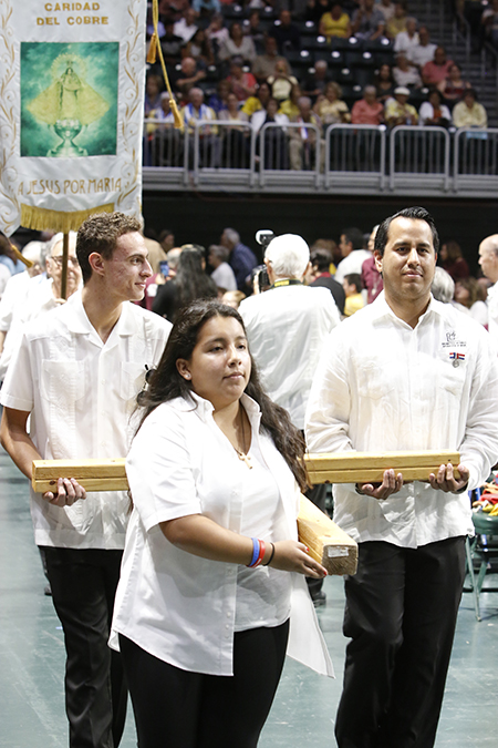 Izzy Rennella (centro) junto con otros integrantes de Encuentros Juveniles cargan la Cruz de Encuentros que lidera la procesión y el inicio de la celebración anual del 2018, de la Virgen de la Caridad.