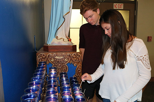 Alexa Reed, 16, and her cousin Joshua Reed, 18, light candles for the souls killed at Marjory Stoneman Douglas High School on the one-year anniversary of the tragic event. They attended a holy hour at Mary Help of Christians in Parkland held to pray for the victims and the families and for peace.