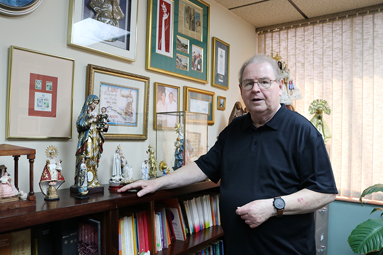 Rogelio Zelada, custodian of the image of Our Lady of Charity at Miami's shrine, is pictured here in his Pastoral Center office surrounded by Marian images, the patronesses of various Latin American countries.